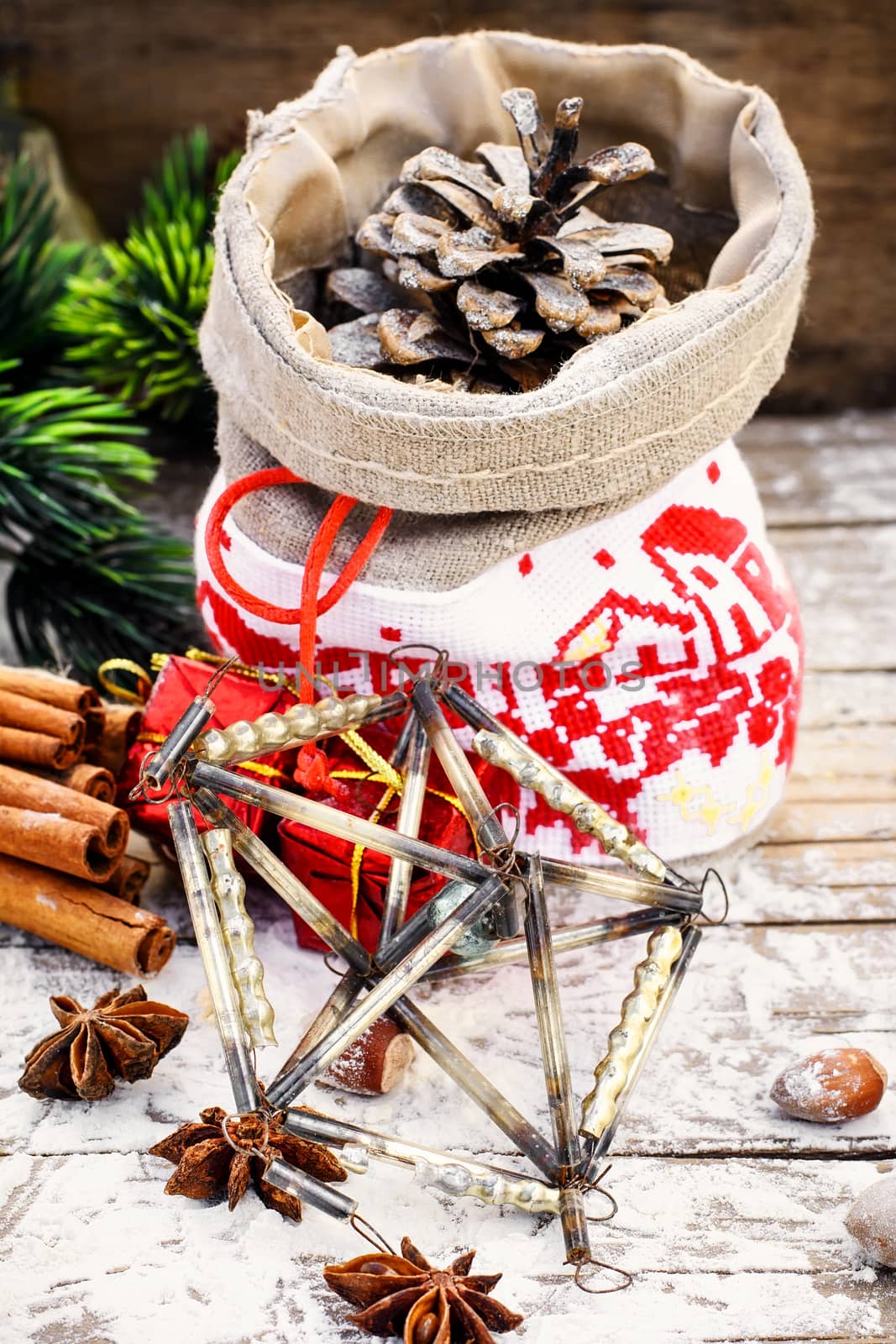Pine and pinecone Christmas decorations on snowy wooden background