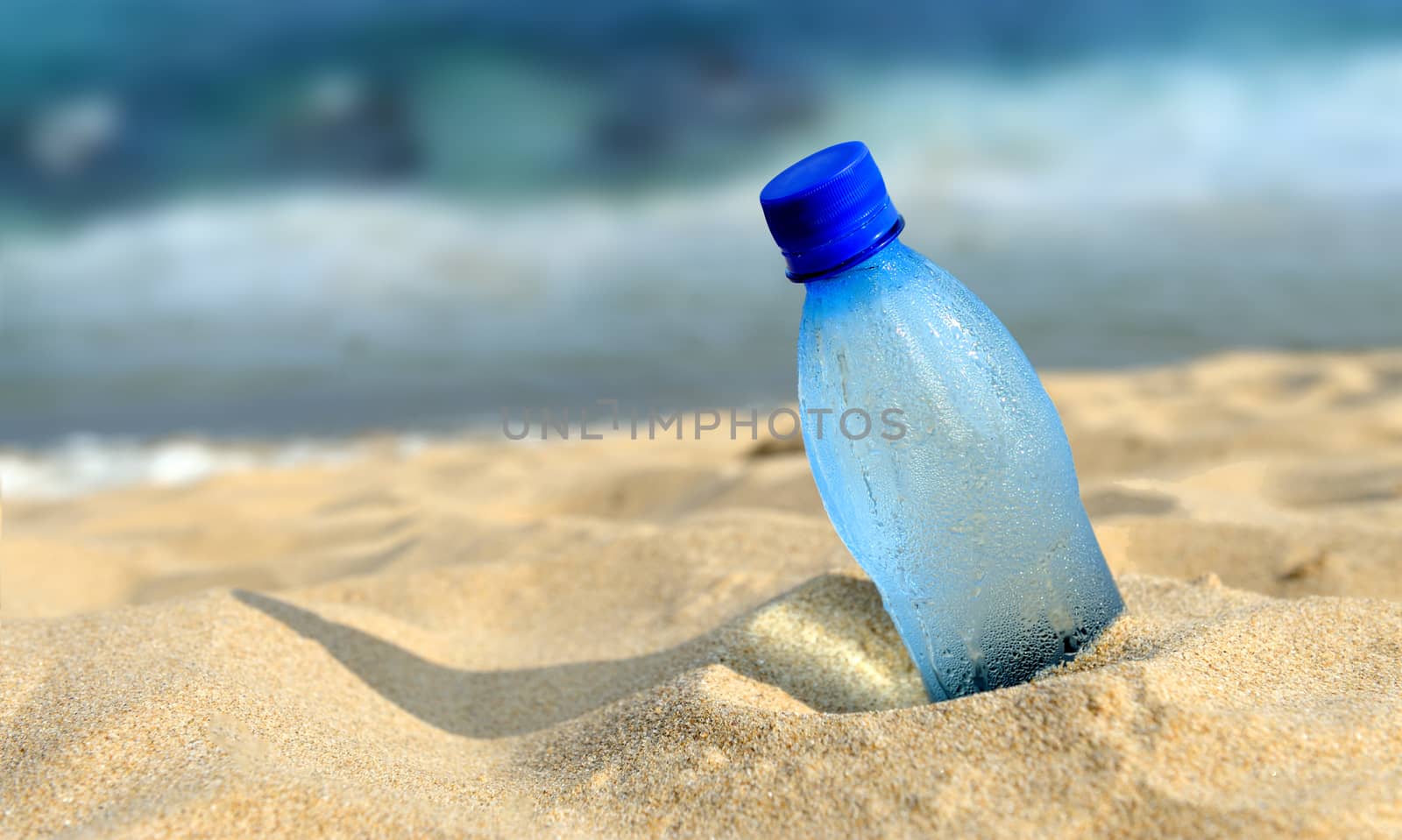 Bottle of the fresh water on the beach