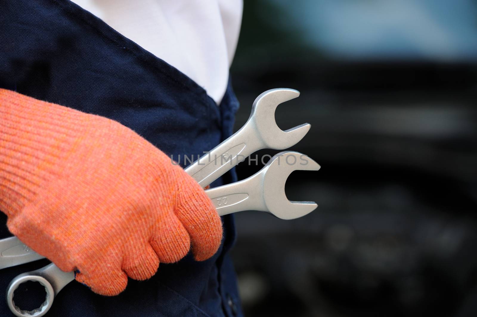 Mechanic holding a wrench at a car garage