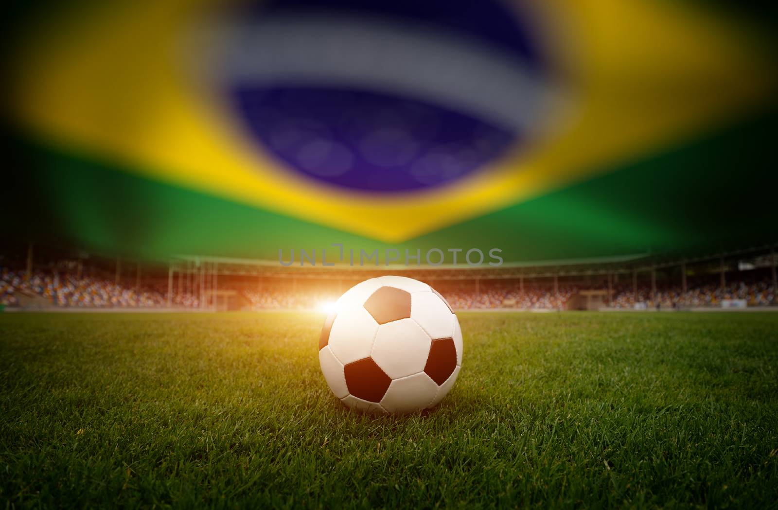 Soccer ball on the field of stadium on Brazil flag background
