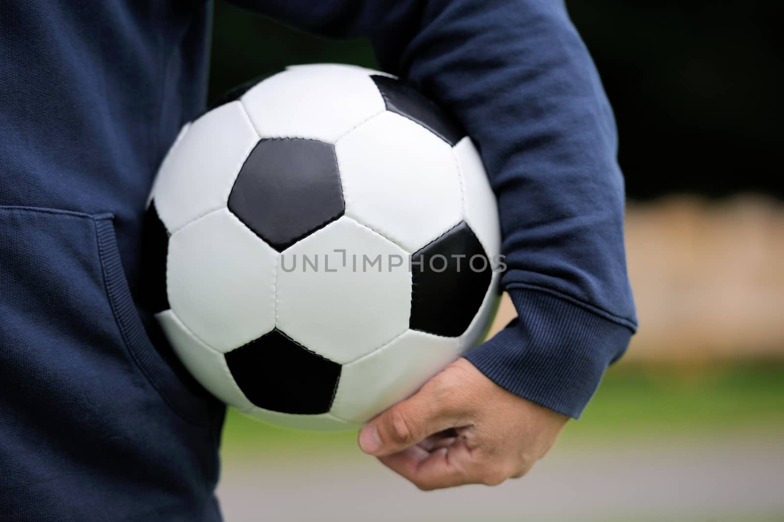 Hand holding soccer ball by byrdyak