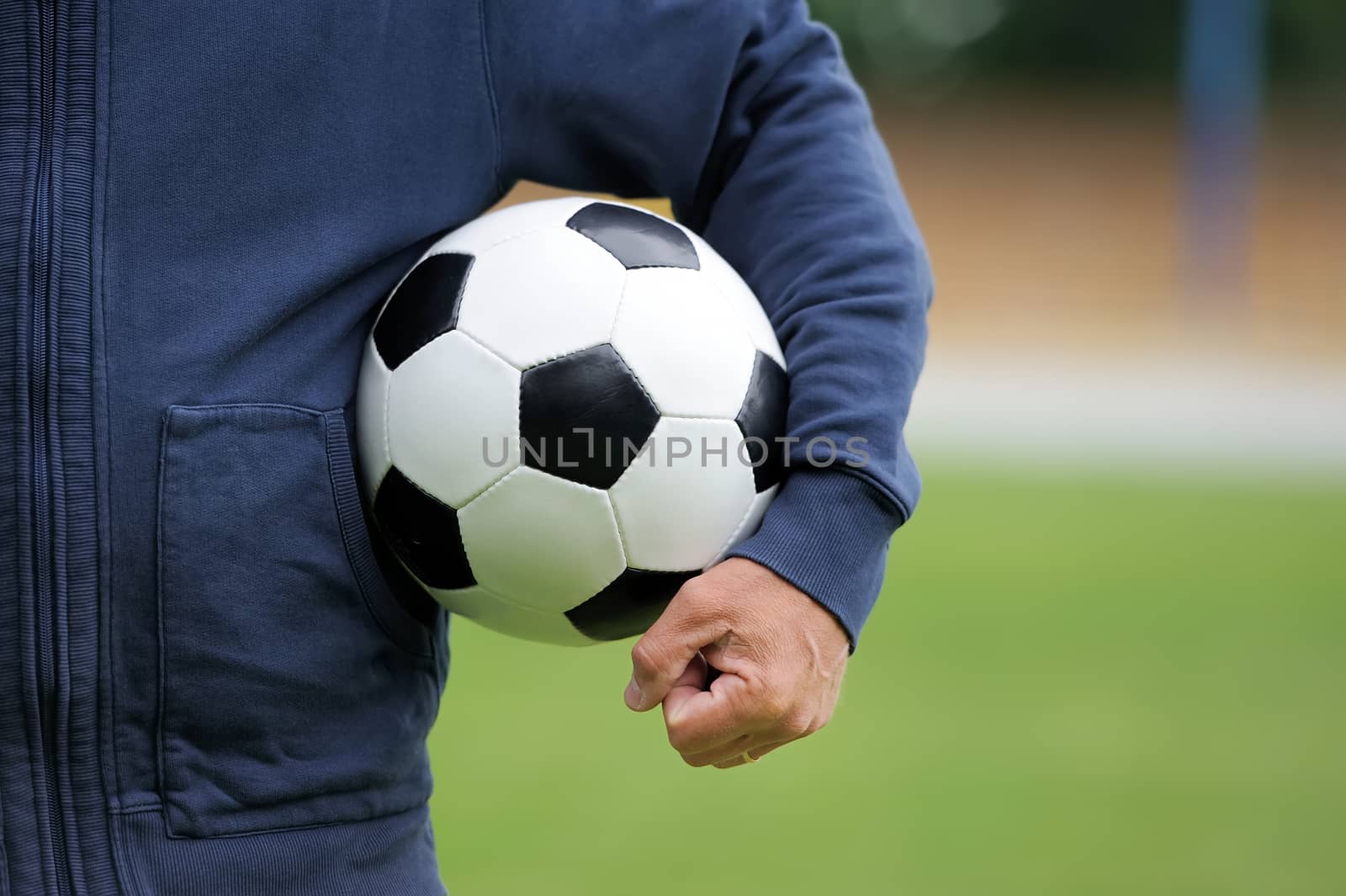Hand holding soccer ball by byrdyak