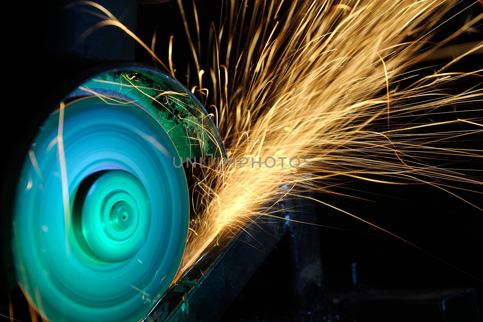 Worker cutting metal with grinder. Sparks while grinding iron