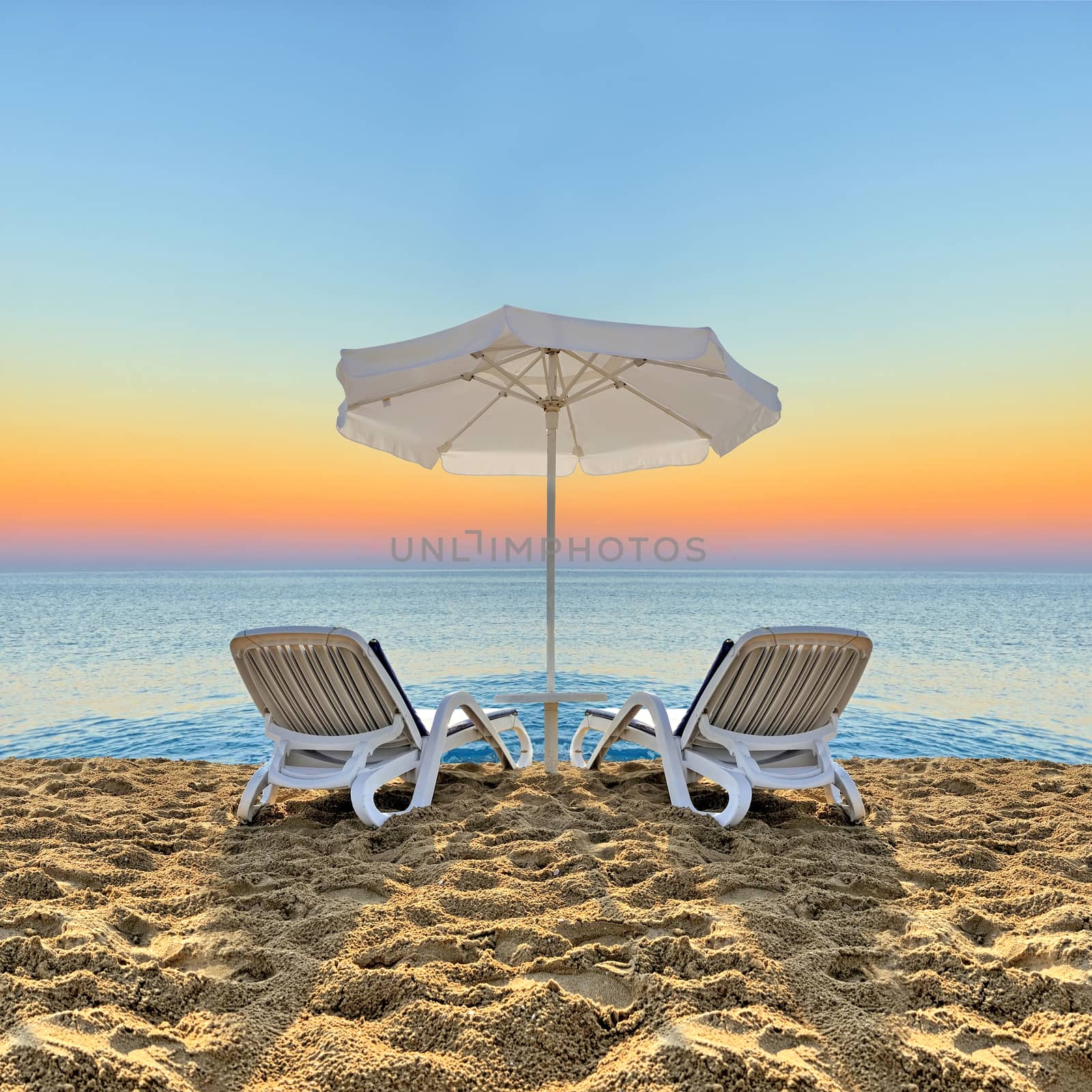 Beach chair and white umbrella on beach by byrdyak
