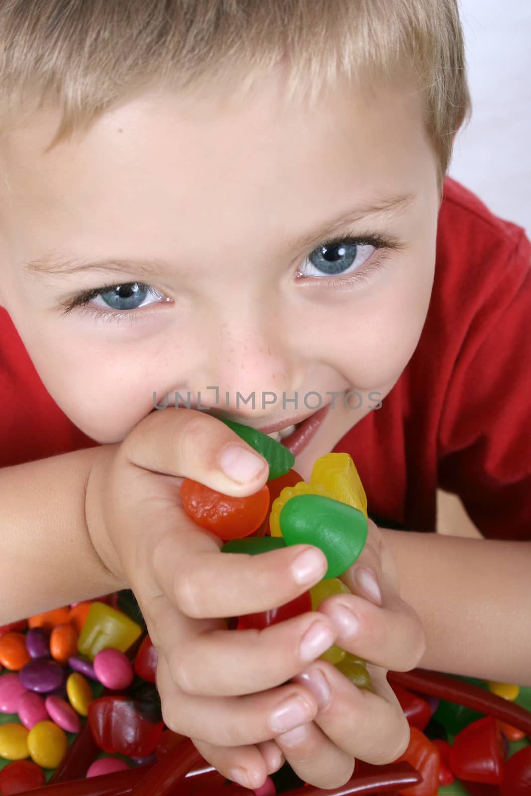 Young boy being with a table full of colorful sweets