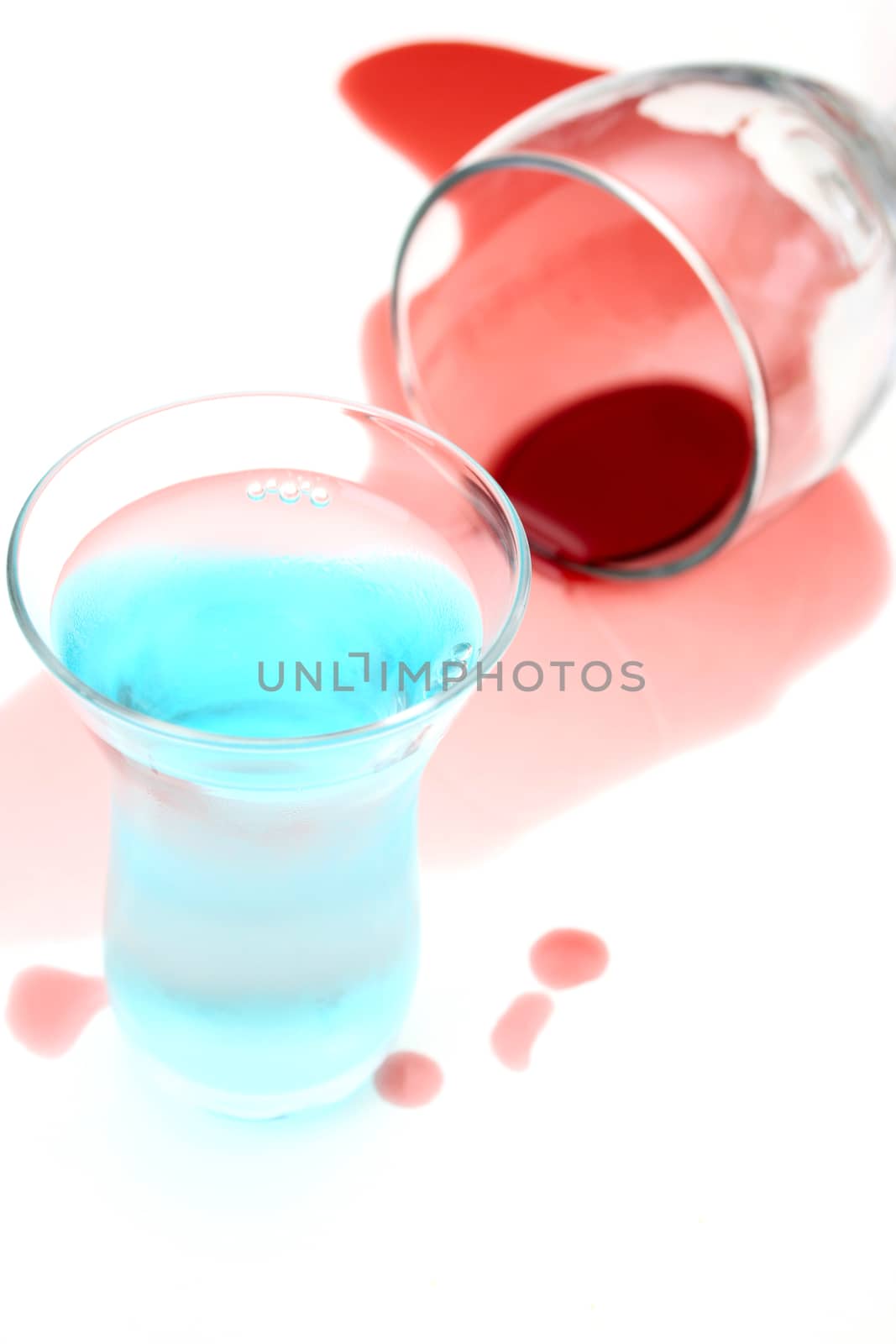 Spilled wine and a shot glass on a white background