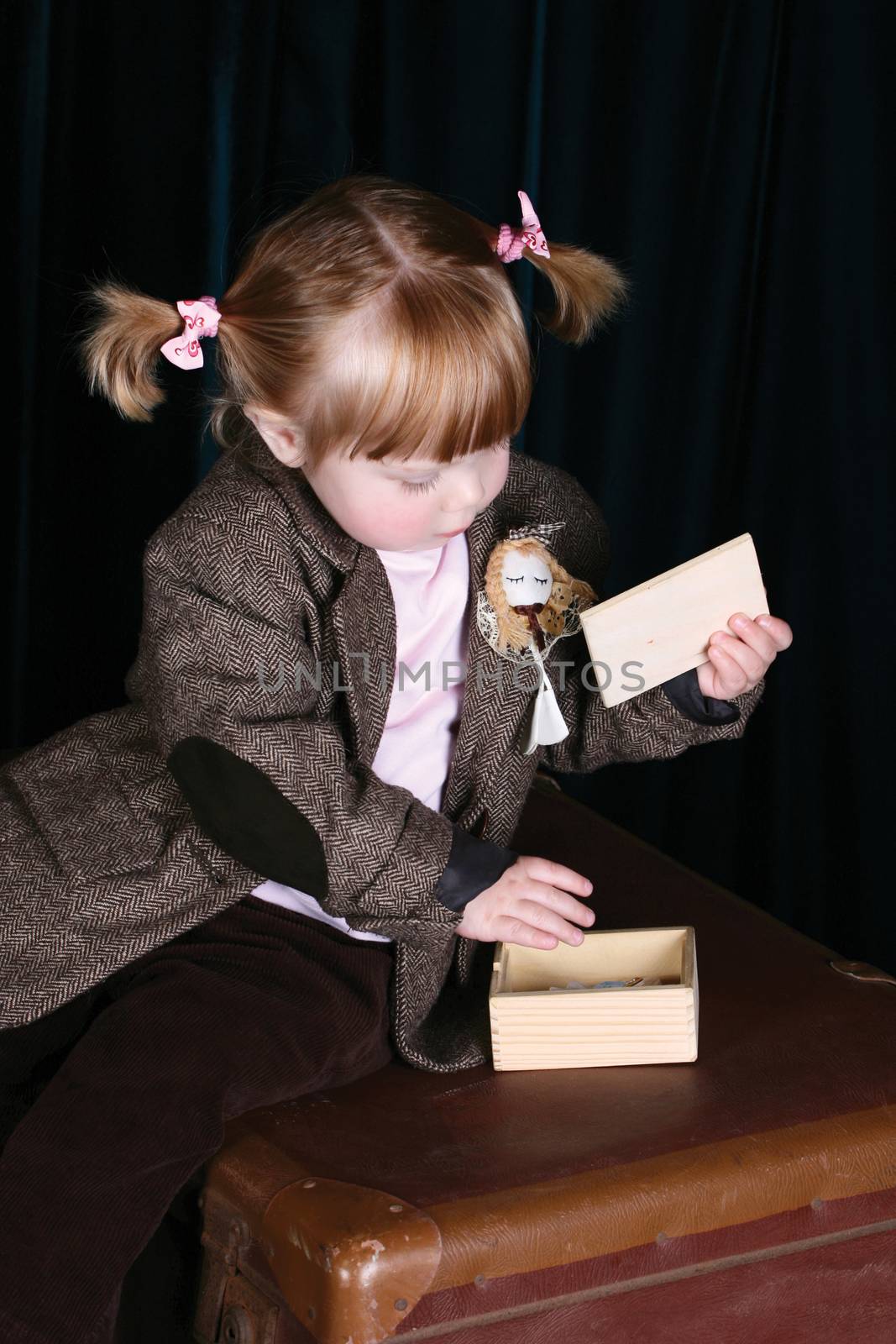 Little girl in vintage attire playing with a puzzle