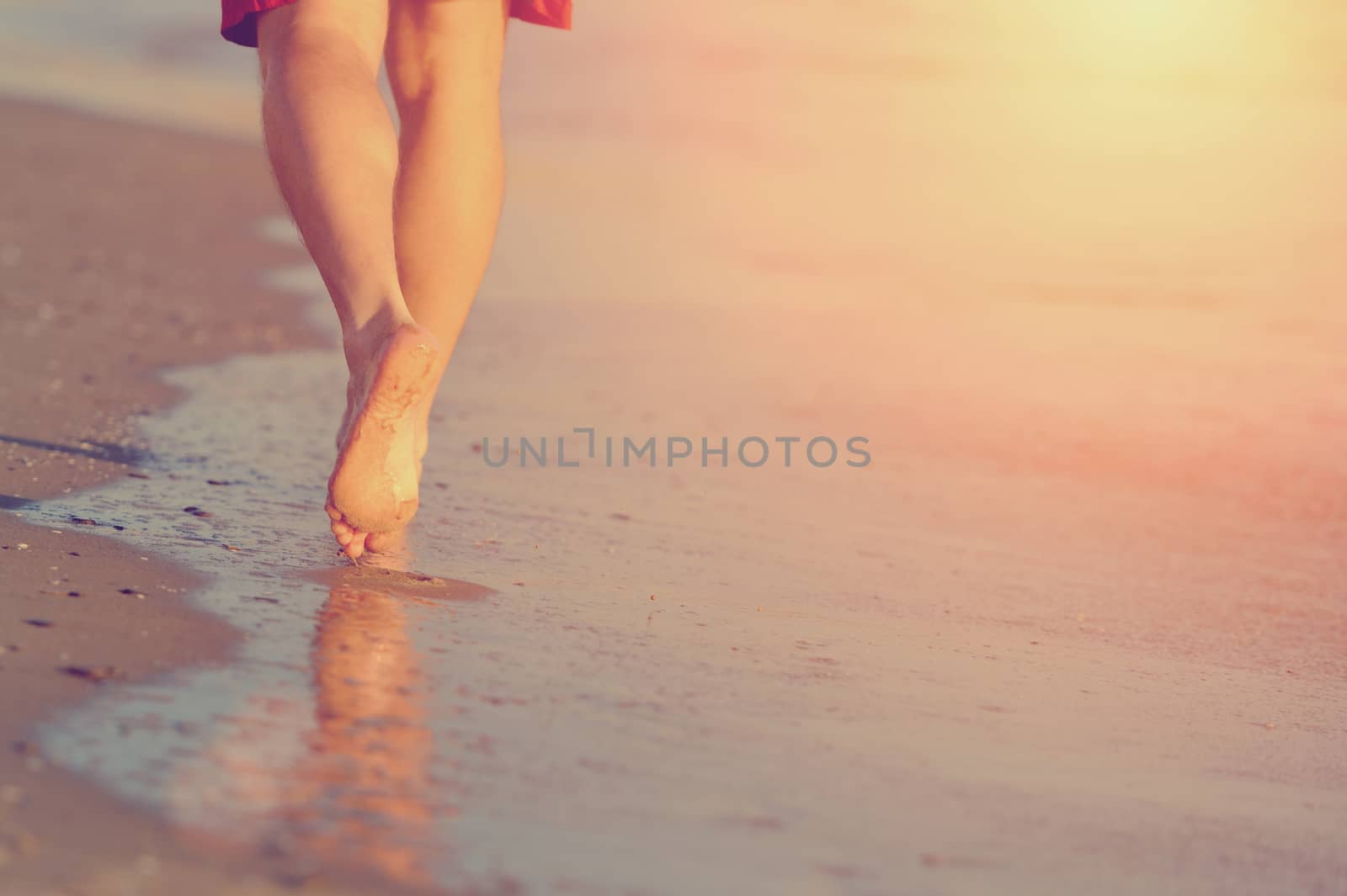 Running legs of runner on beach by byrdyak