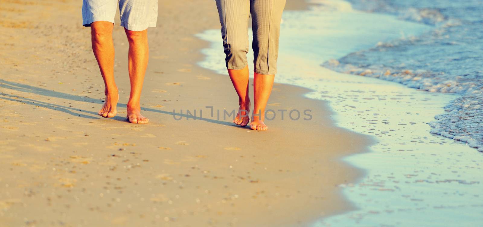 close-up of a romantic couple walking together along the beach