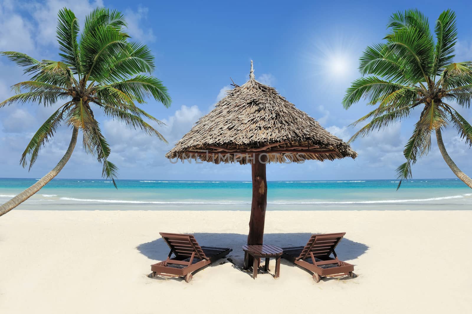 Beautiful tropical beach witn straw umbrella and palm. Straw umbrella and palm at the beach