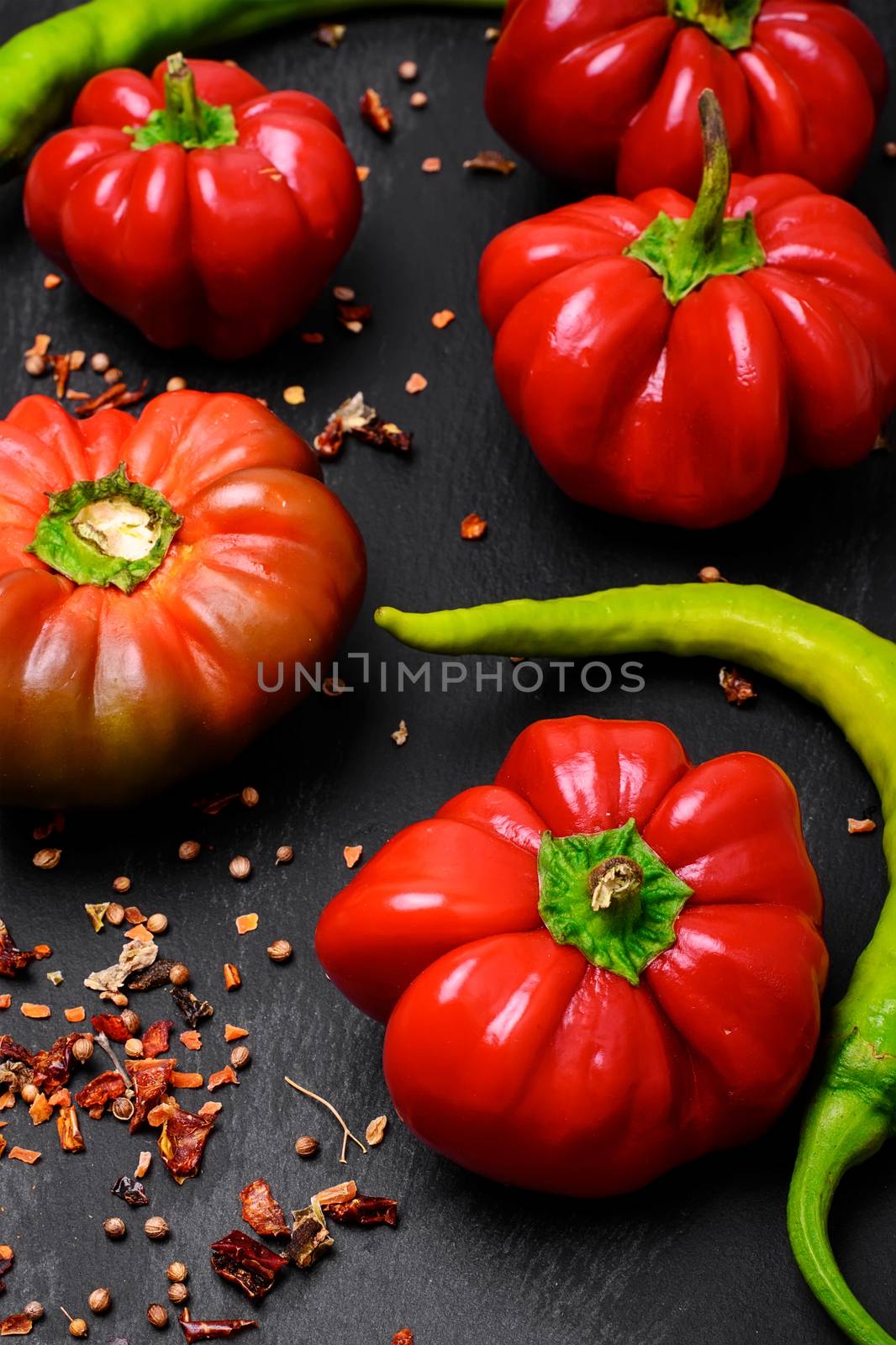 Red bell pepper, and spices on dark background