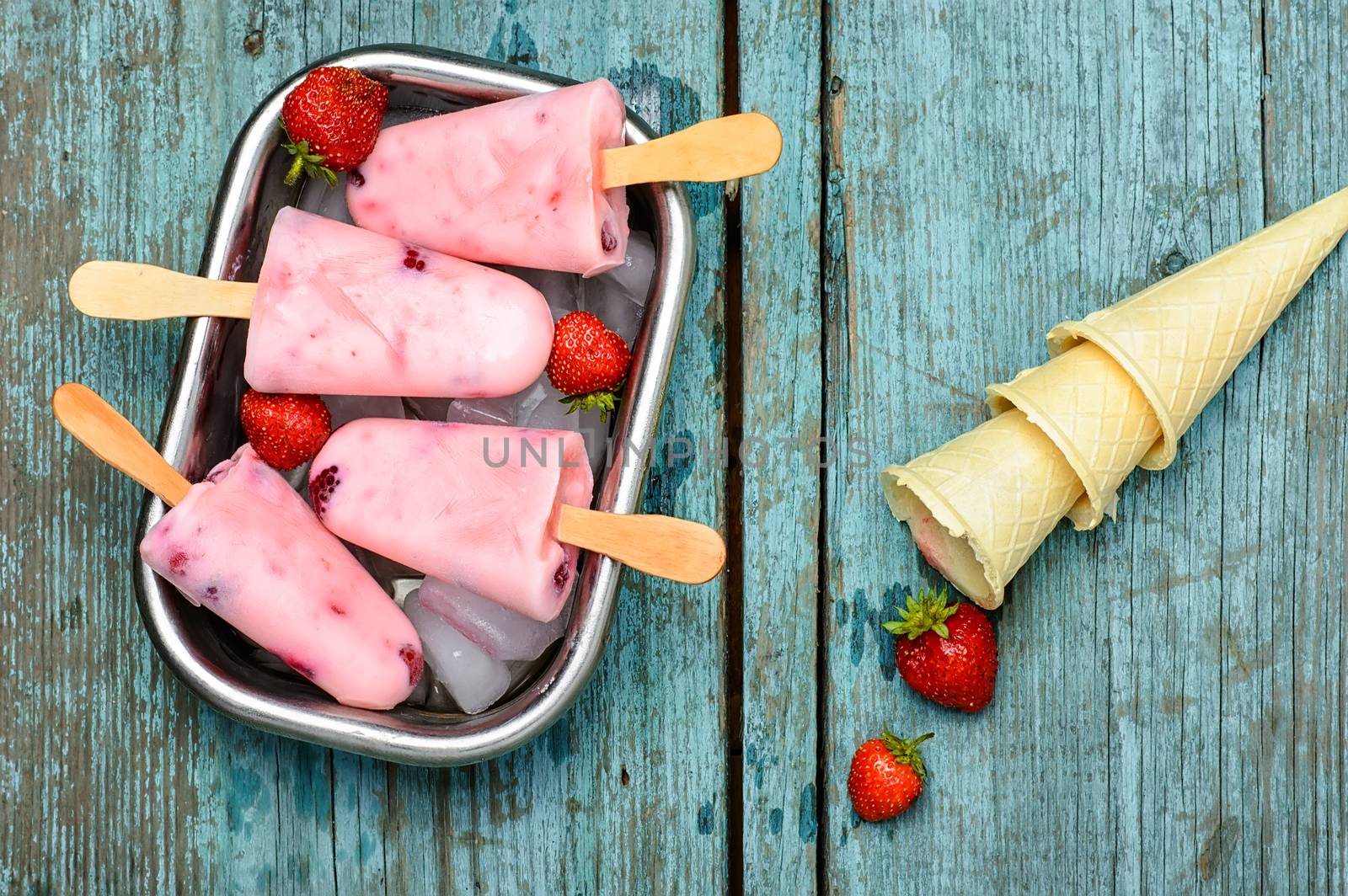 Ice-cream and summer berries in metal tray with ice