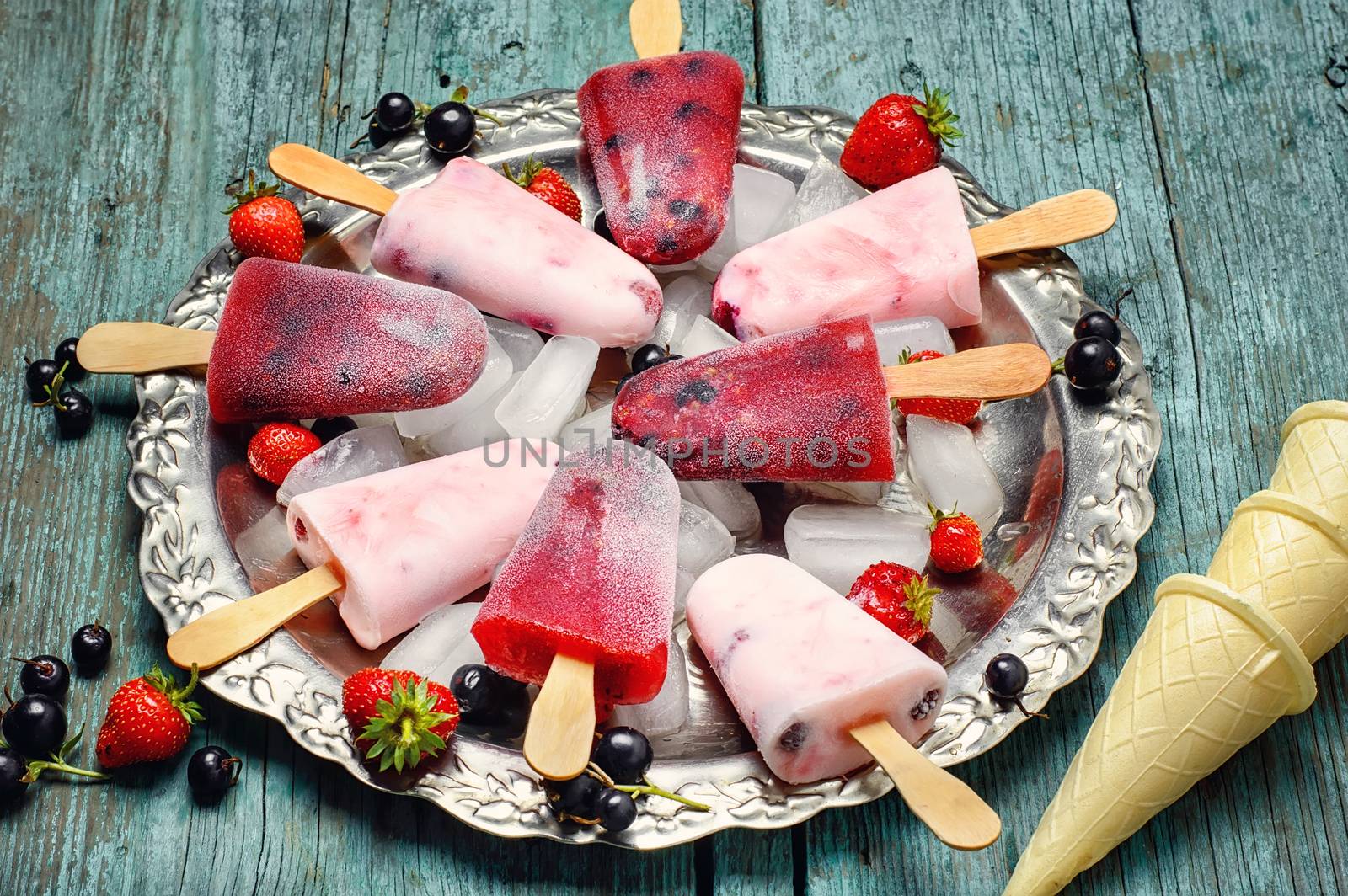 Ice-cream and summer berries in metal tray with ice