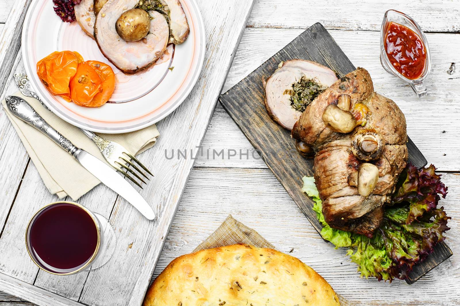 Meatloaf sliced on kitchen board with ketchup and vegetables