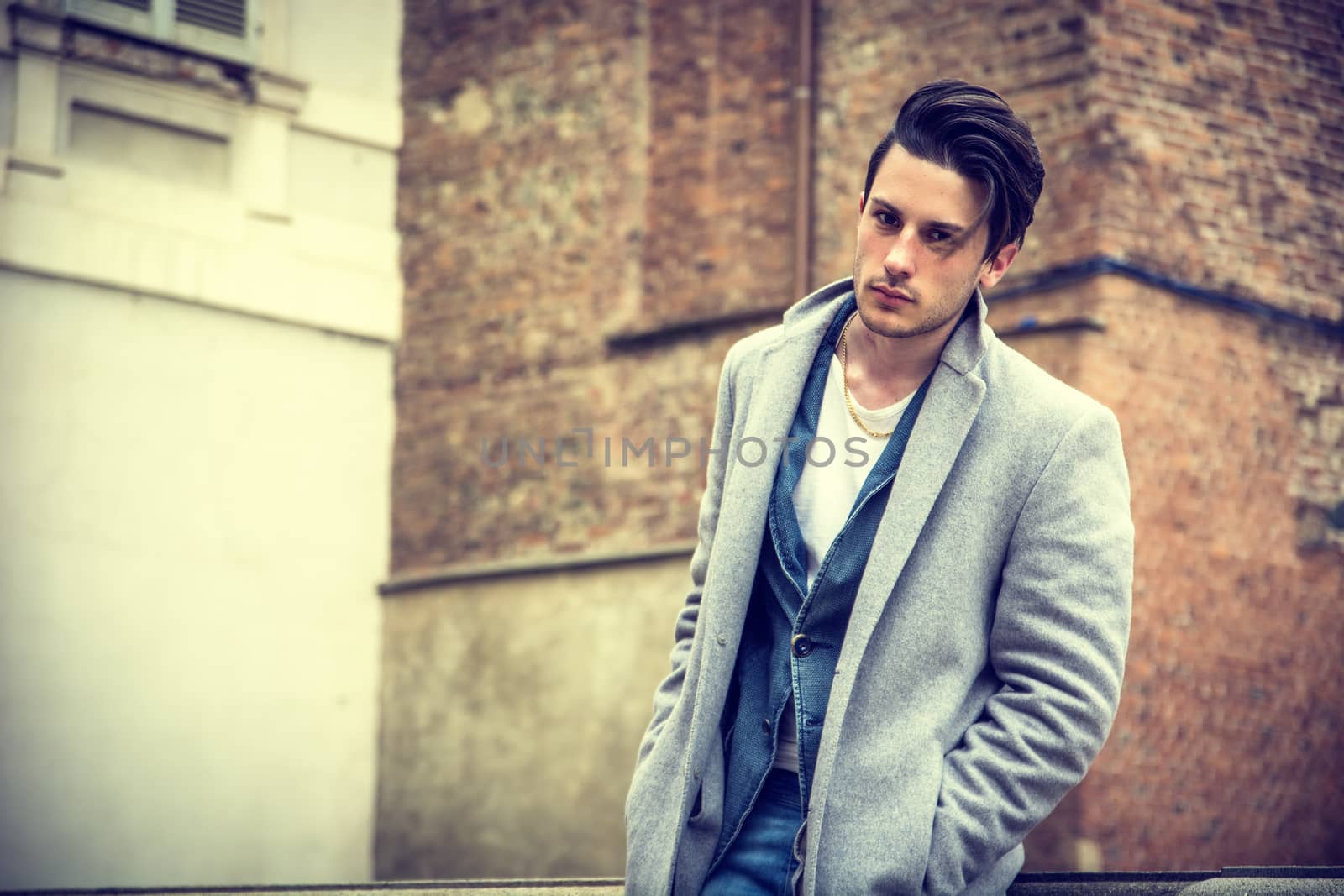 Elegant attractive young man outdoor wearing wool coat, in European city