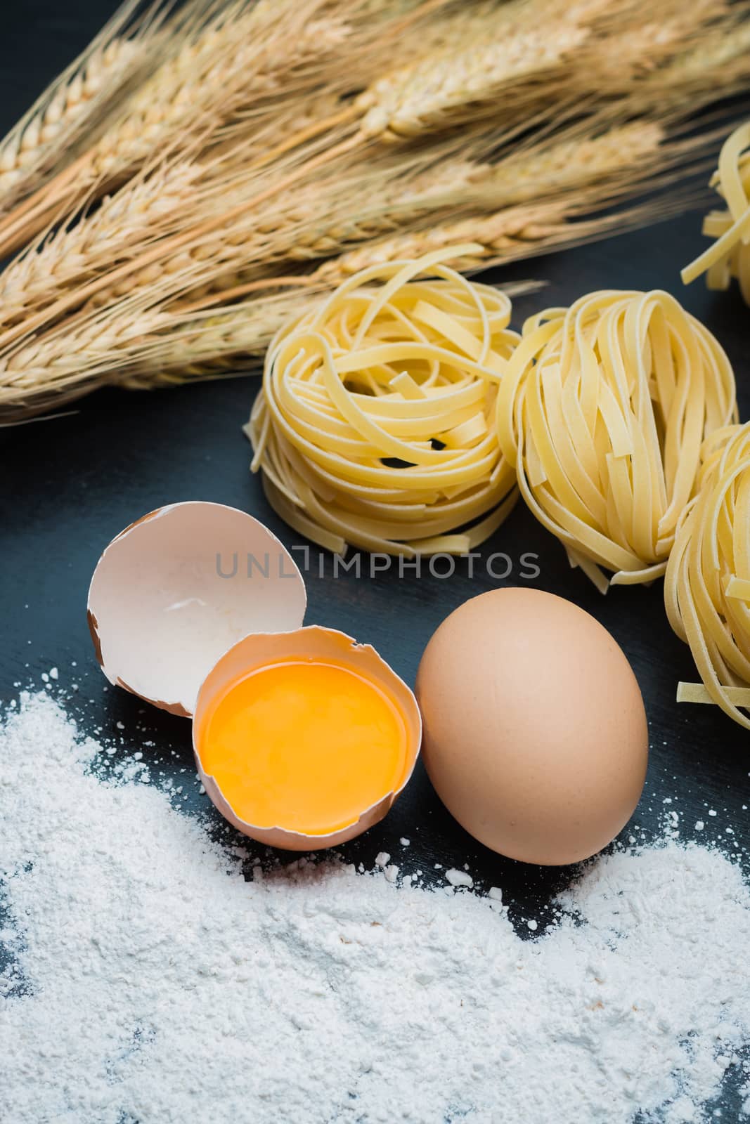 clean Food eggs, wheat flour, Pasta and barley on black wood background