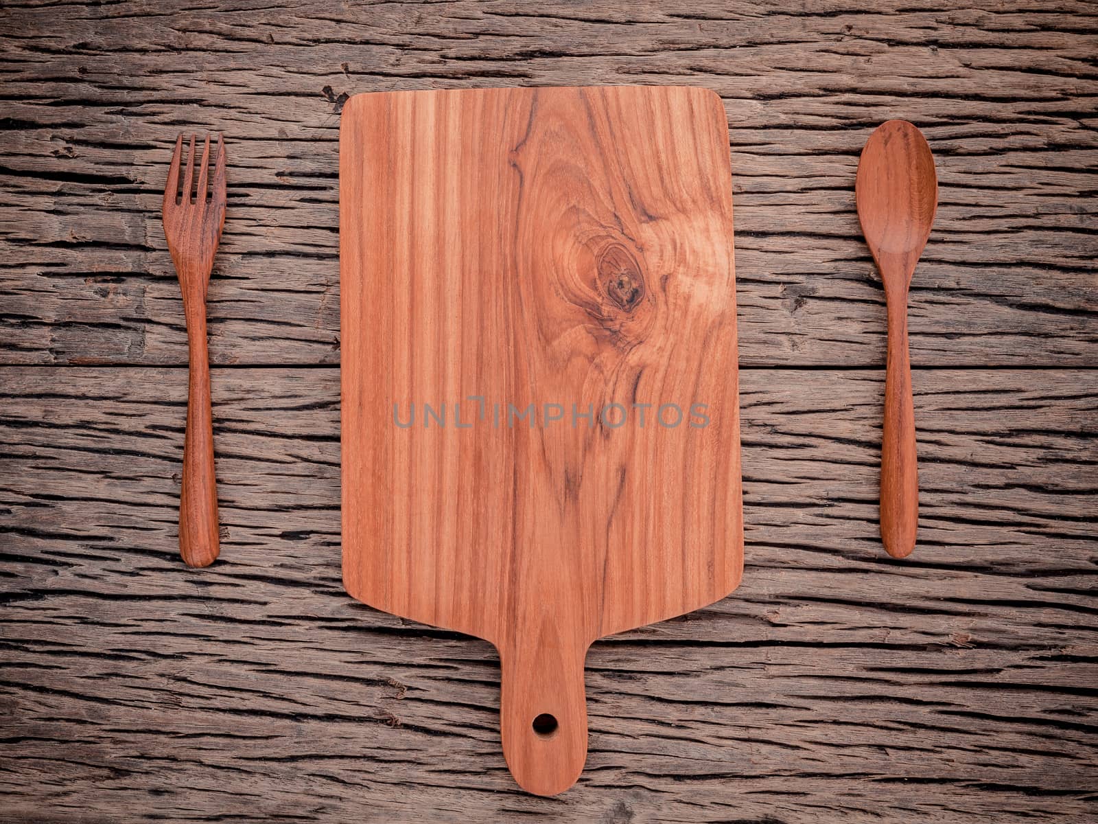 Empty vintage Teak wood cutting board ,fork and spoon on grunge  by kerdkanno