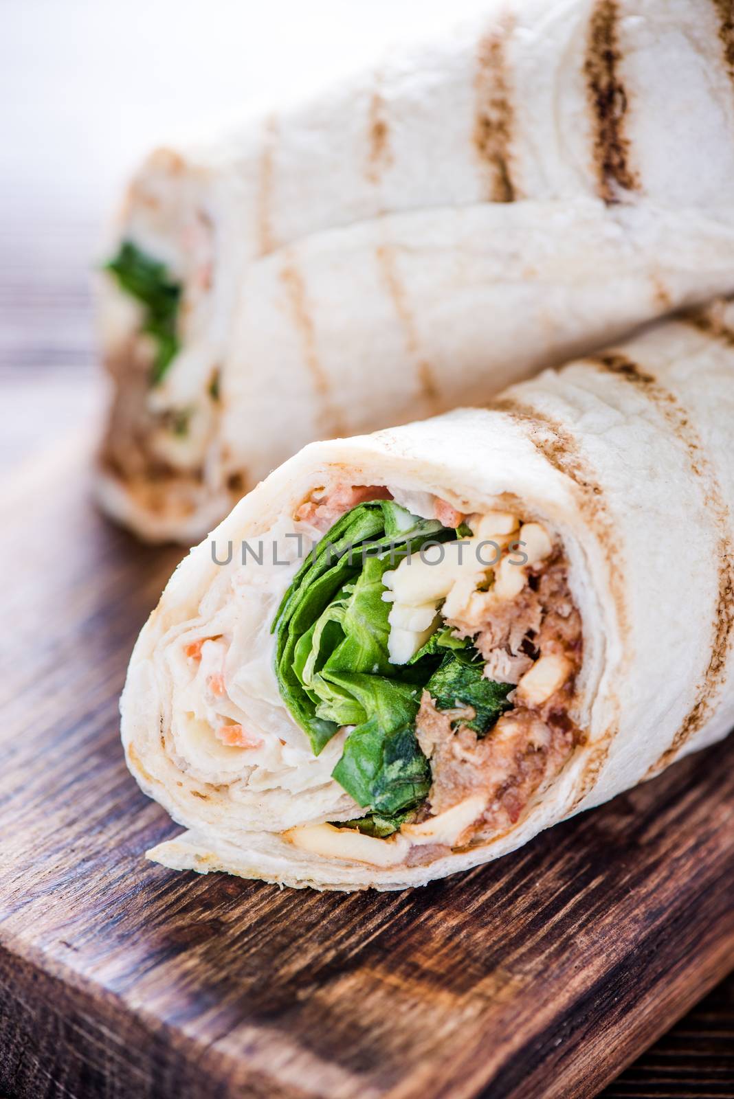 Healthy chicken grilled wrap, on wooden serving board