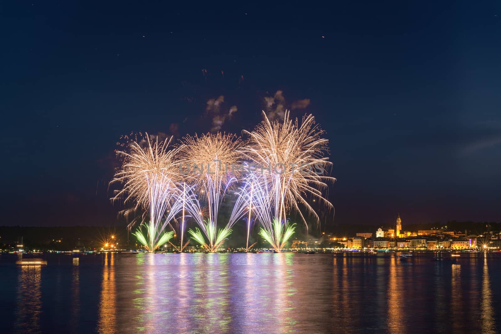 Fireworks on the lakefront of Arona in a summer party night seen from Angera, Major Lake- Piedmont