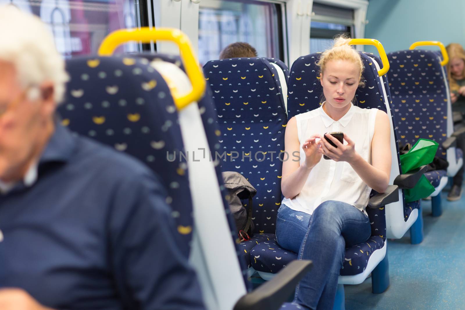 Woman workin on smart phone while traveling by train. Business travel concept.