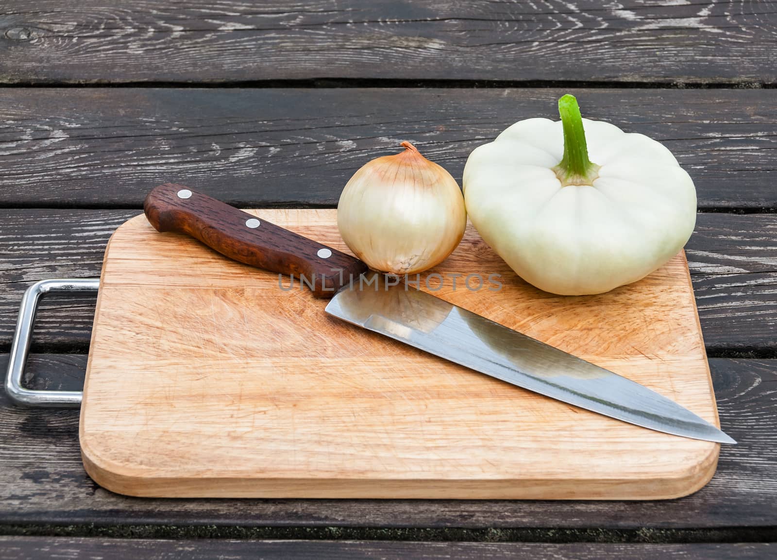 Onions, squash and knife on board by zeffss