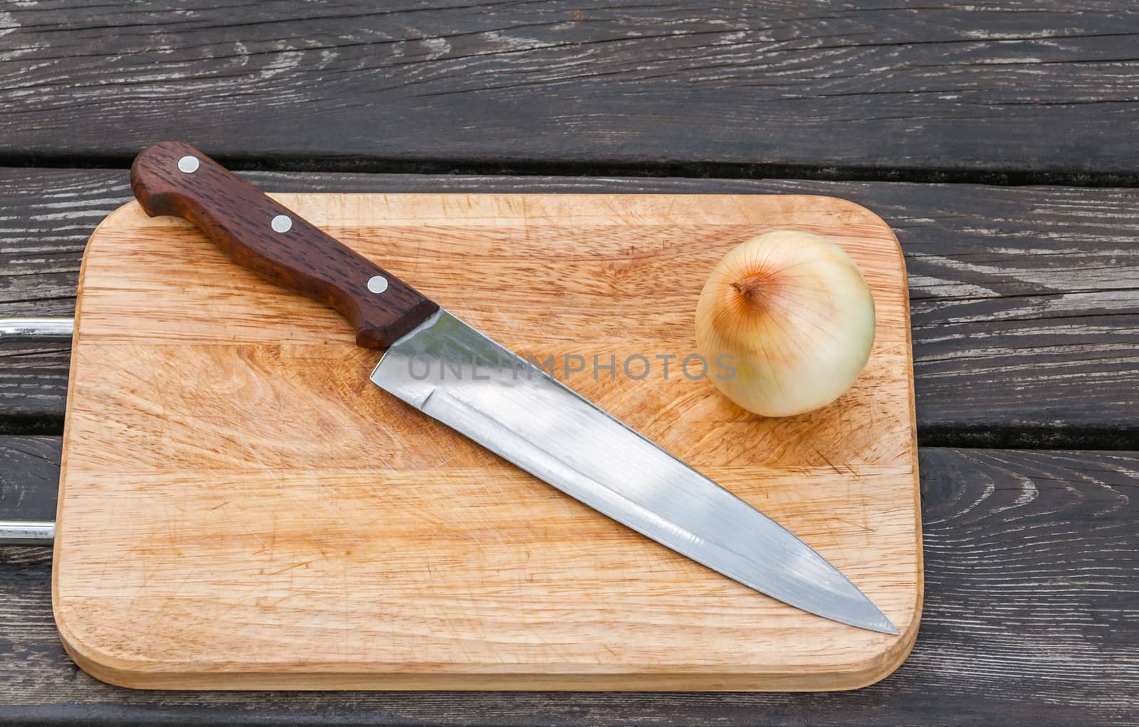 Steel knife,onion and a cutting chopping board