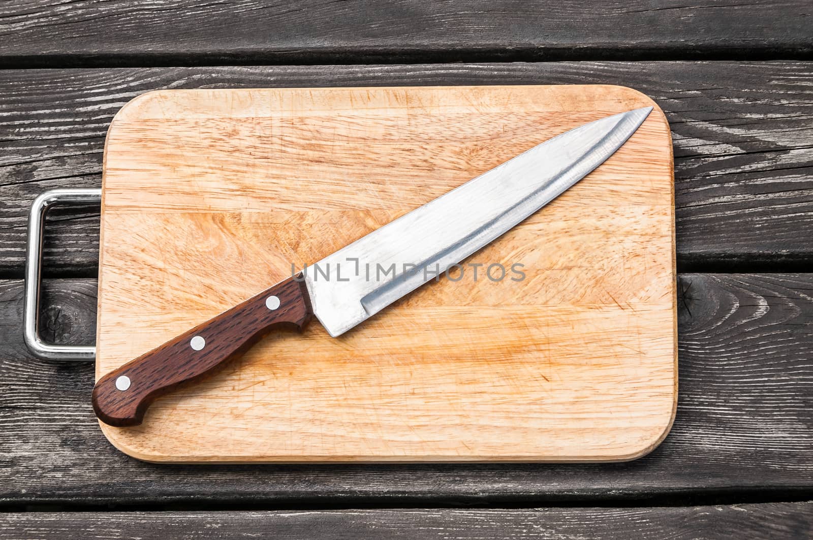 Steel knife on a cutting board  wooden background with by zeffss