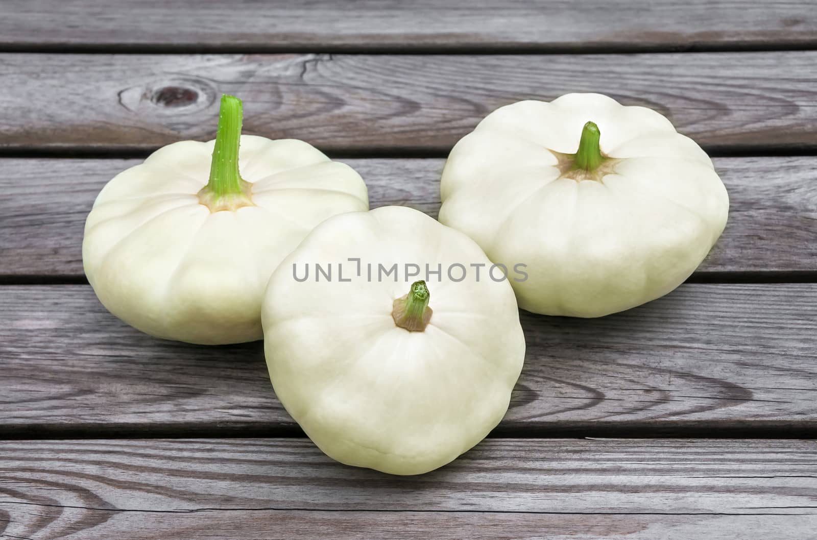 three raw squash on the wooden table