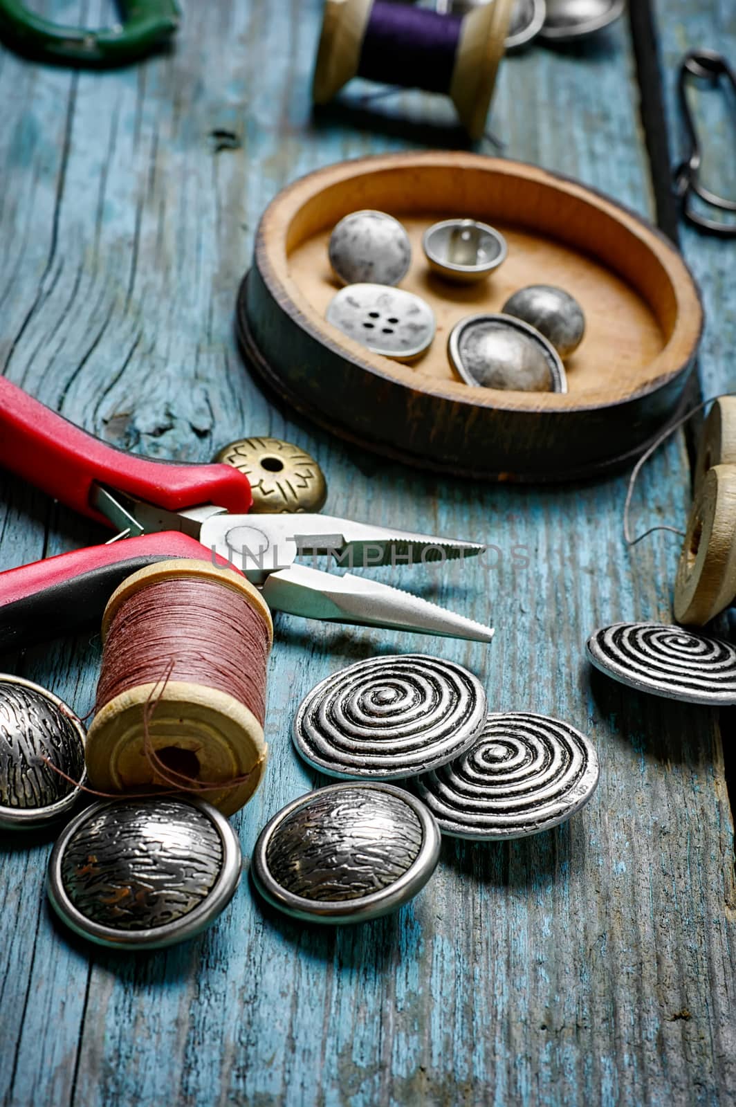 Scissors ,iron, stylish old-fashioned buttons and thread on wooden background