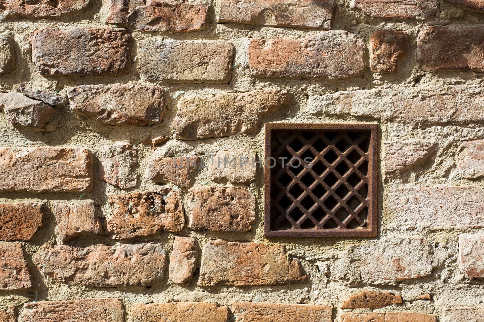 View of a detail of an ancient wall with grate