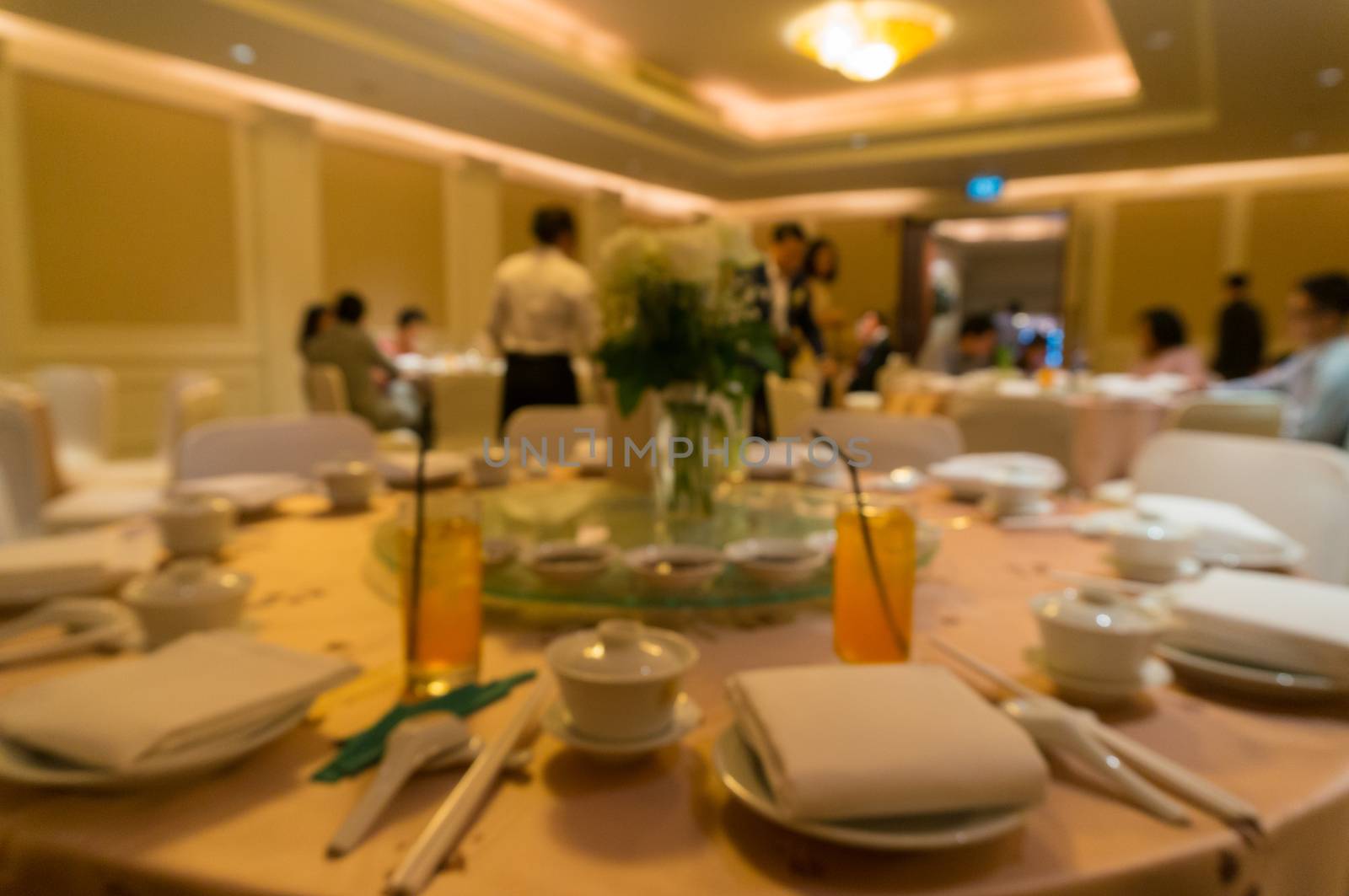 blurred image of Large dining table set for wedding, dinner or f by thampapon