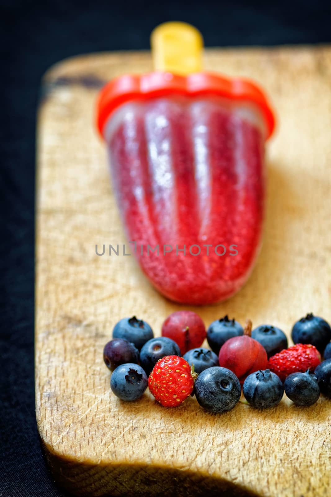 homemade popsicle on wood with berries