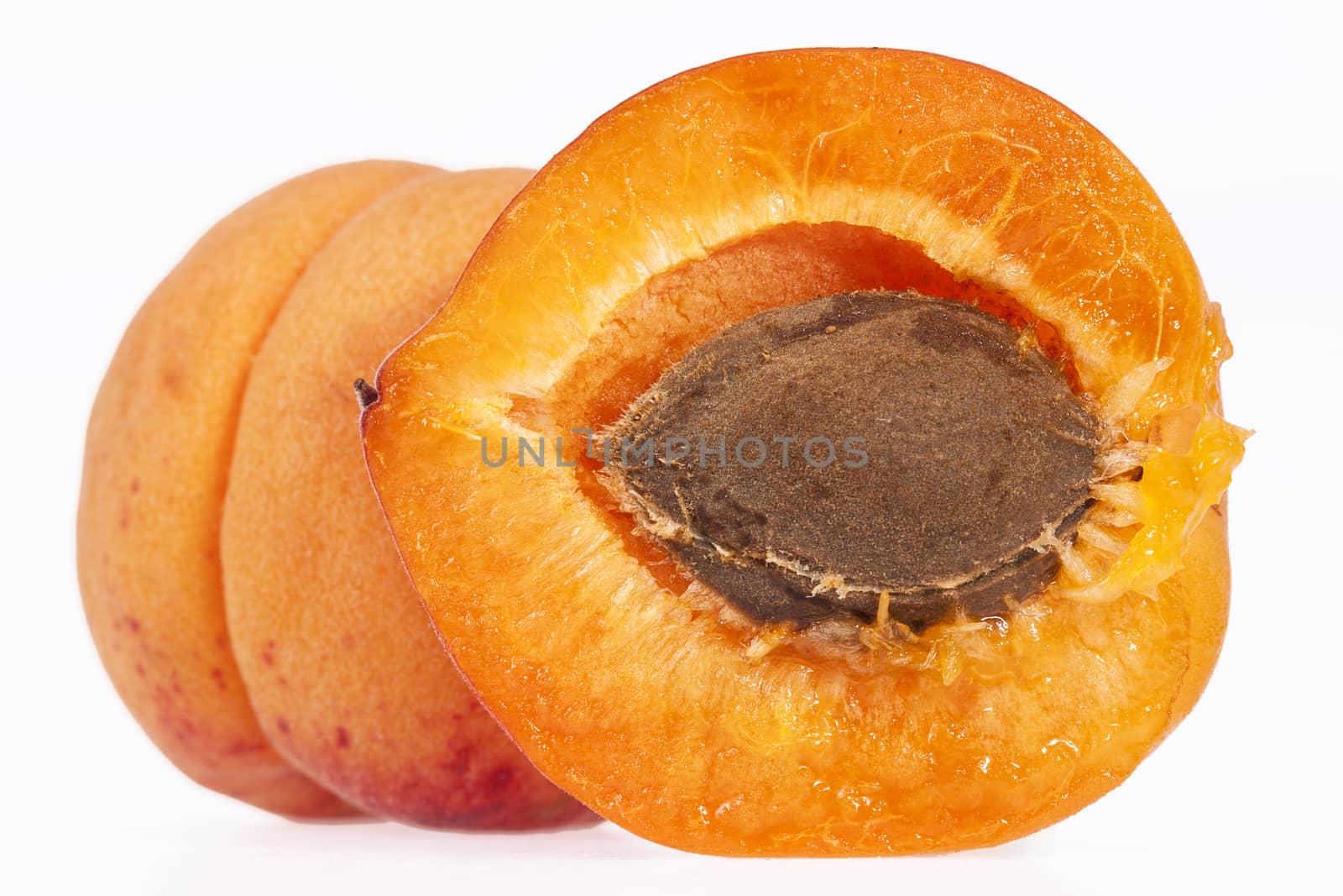 Whole and cut ripe fruits of apricot isolated on white background, close up.