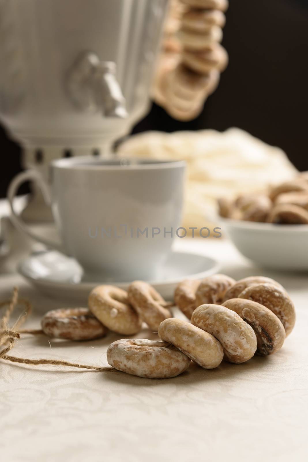 a samovar with bagels and hot tea on the white tablecloth