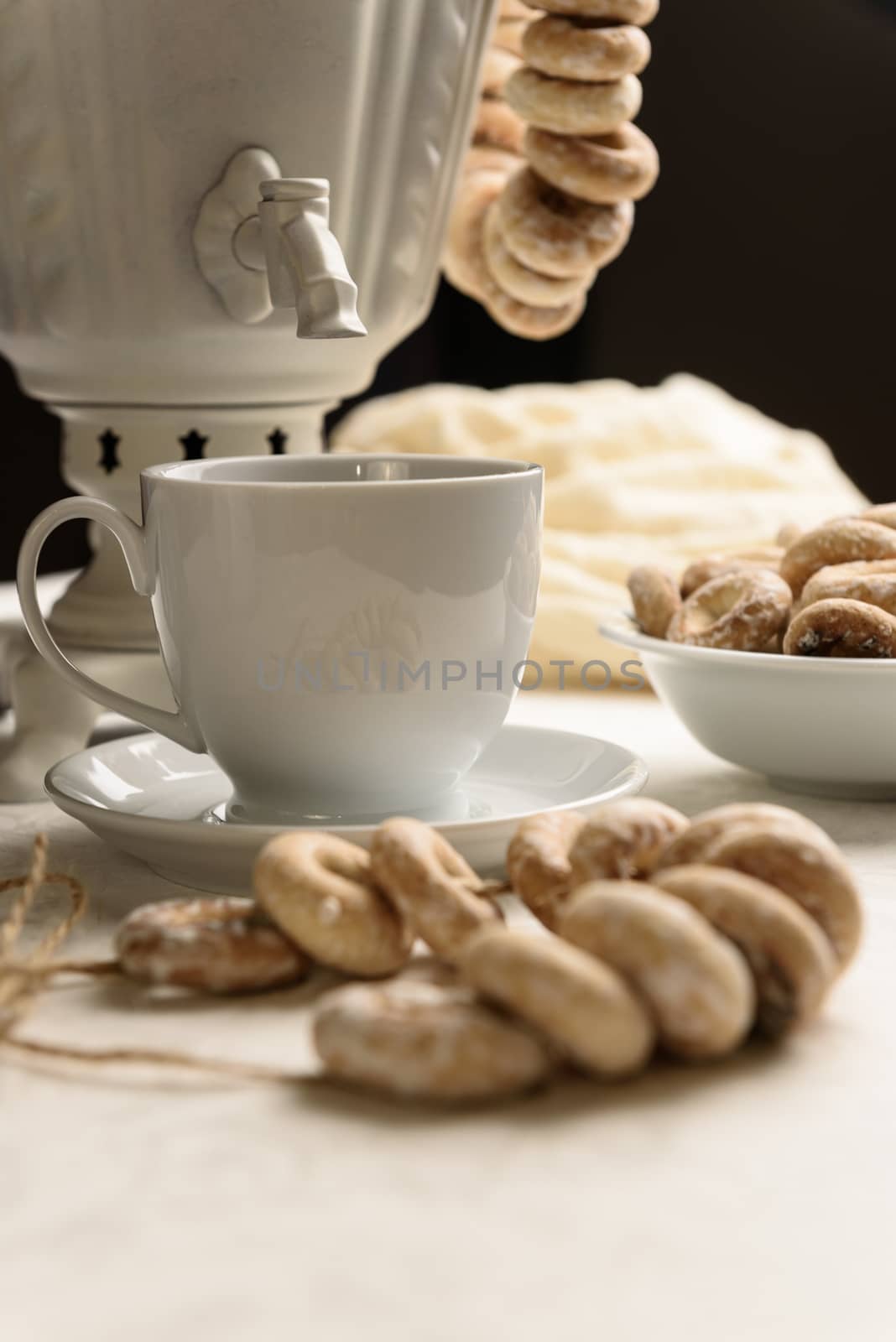 a samovar with bagels and hot tea on the white tablecloth