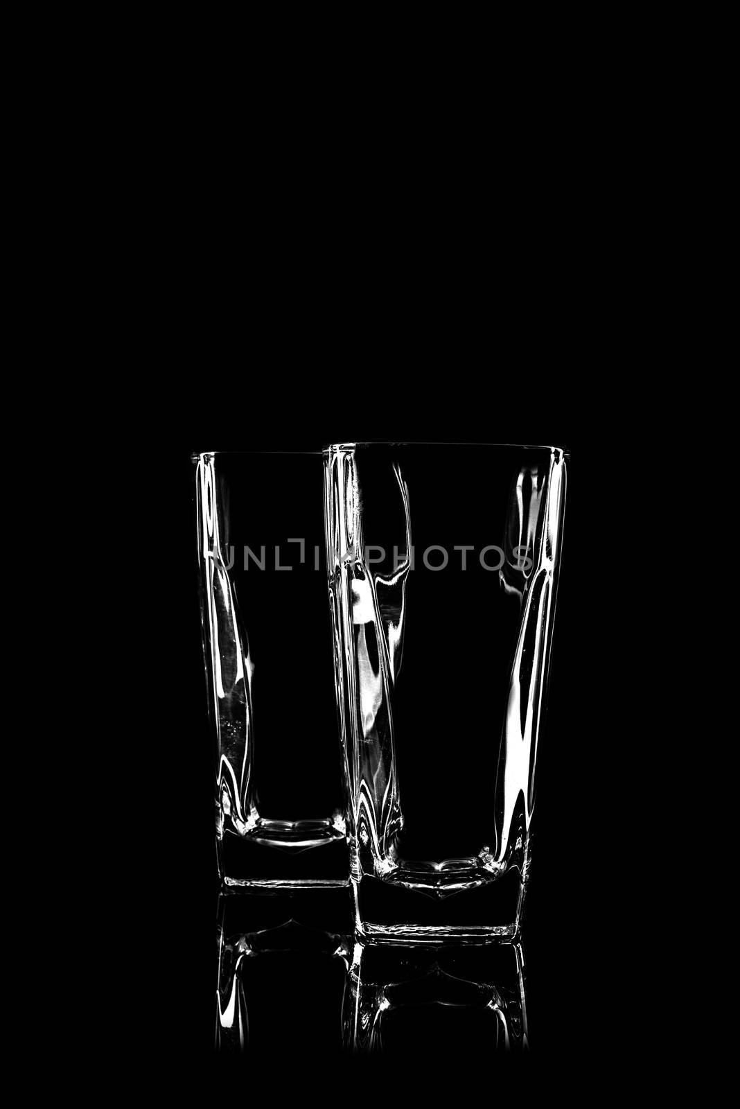 transparent glass for brandy or cognac on black background with reflection