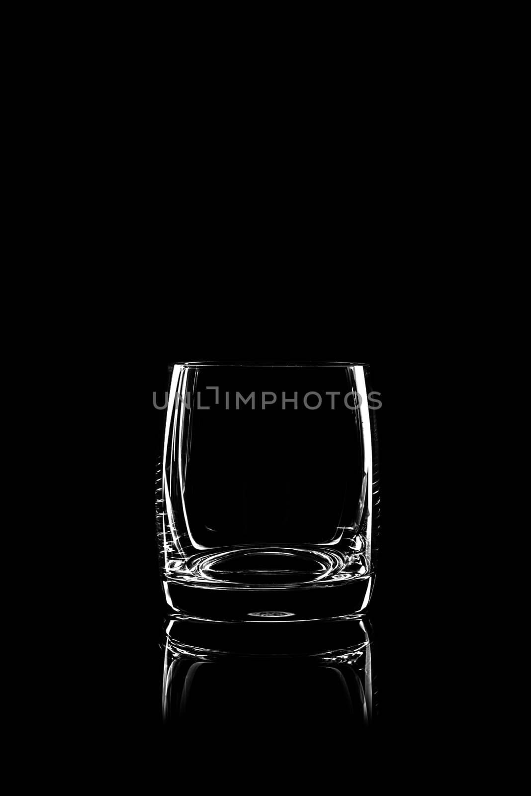 transparent glass for brandy or cognac on black background with reflection