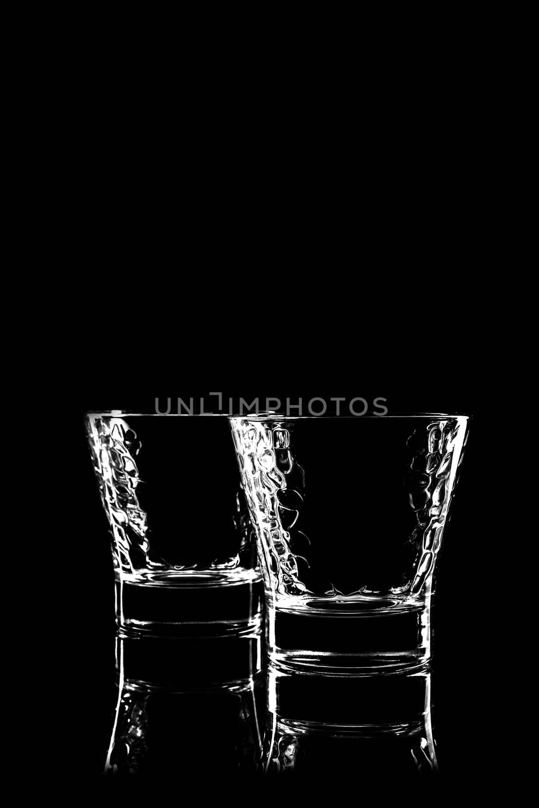 transparent glass for brandy or cognac on black background with reflection