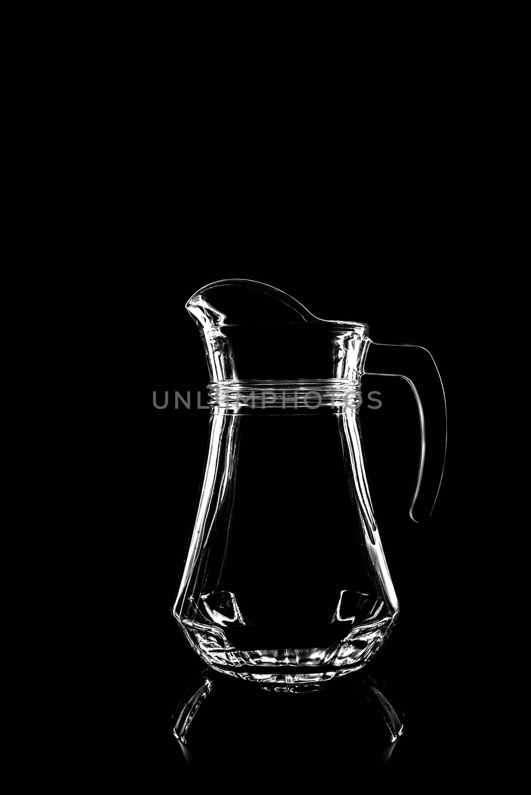 transparent glass for juice on black background with reflection