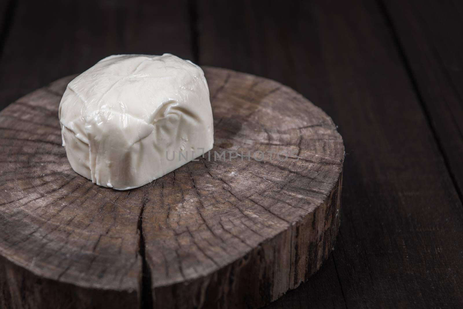 white mozzarella cheese on a wooden end of a tree