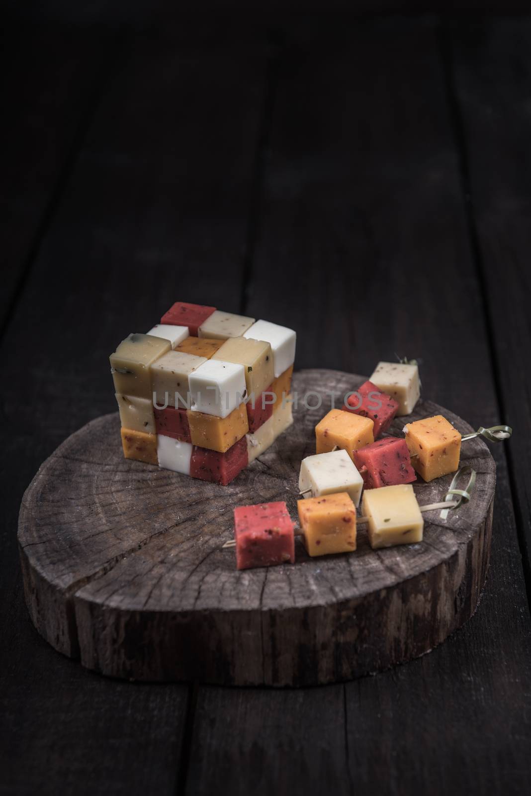 many kinds of cheeses on wooden end of a tree