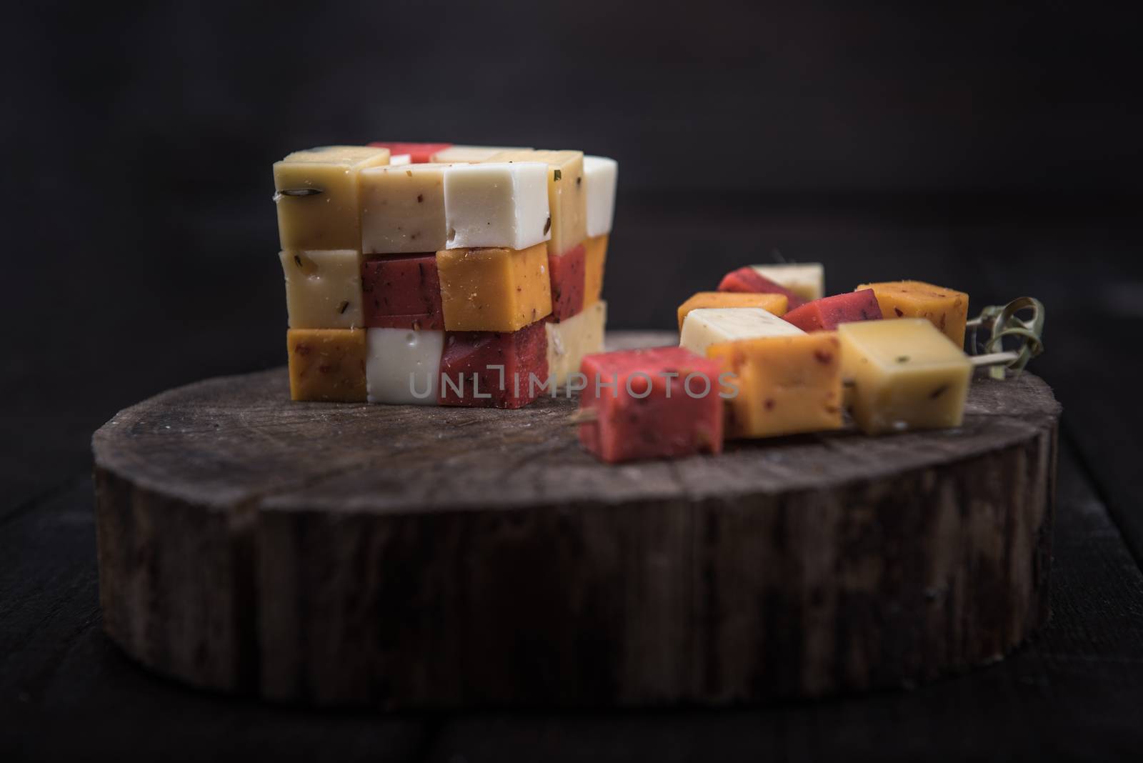 many kinds of cheeses on wooden end of a tree