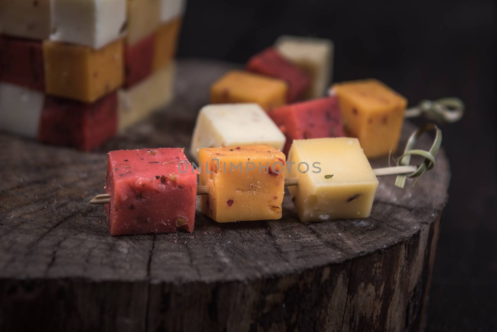 many kinds of cheeses on wooden end of a tree