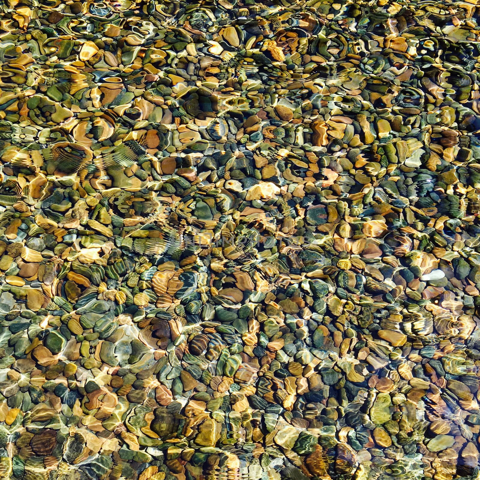 top view water reflection with stone pebbles  by polarbearstudio