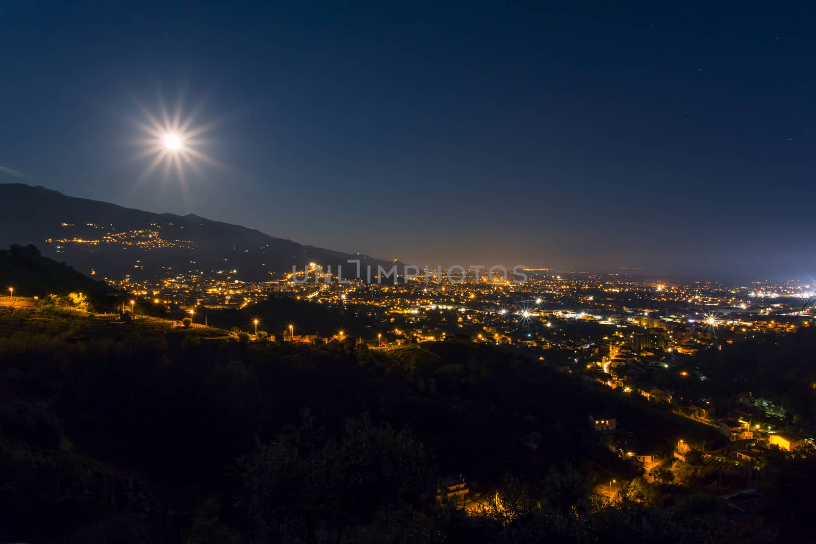 Night panoramic view of the city of Massa with full moon