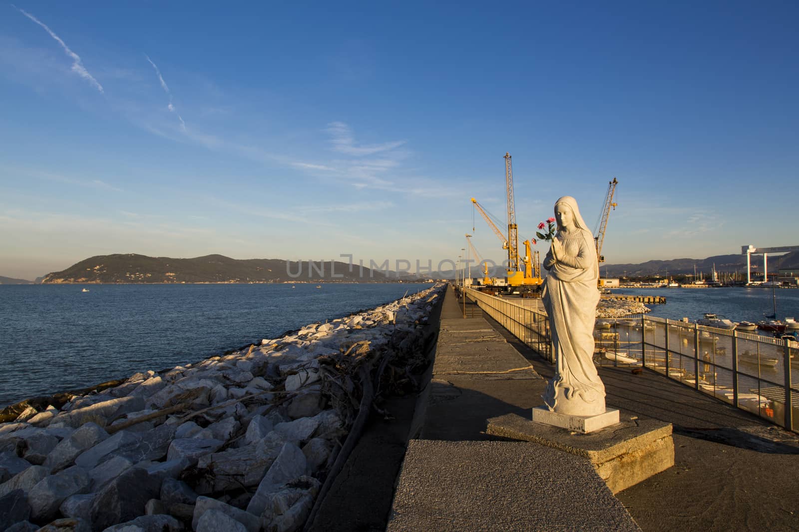 Close up view of the Virgin Mary patroness of seafarers and port with cranes in the background