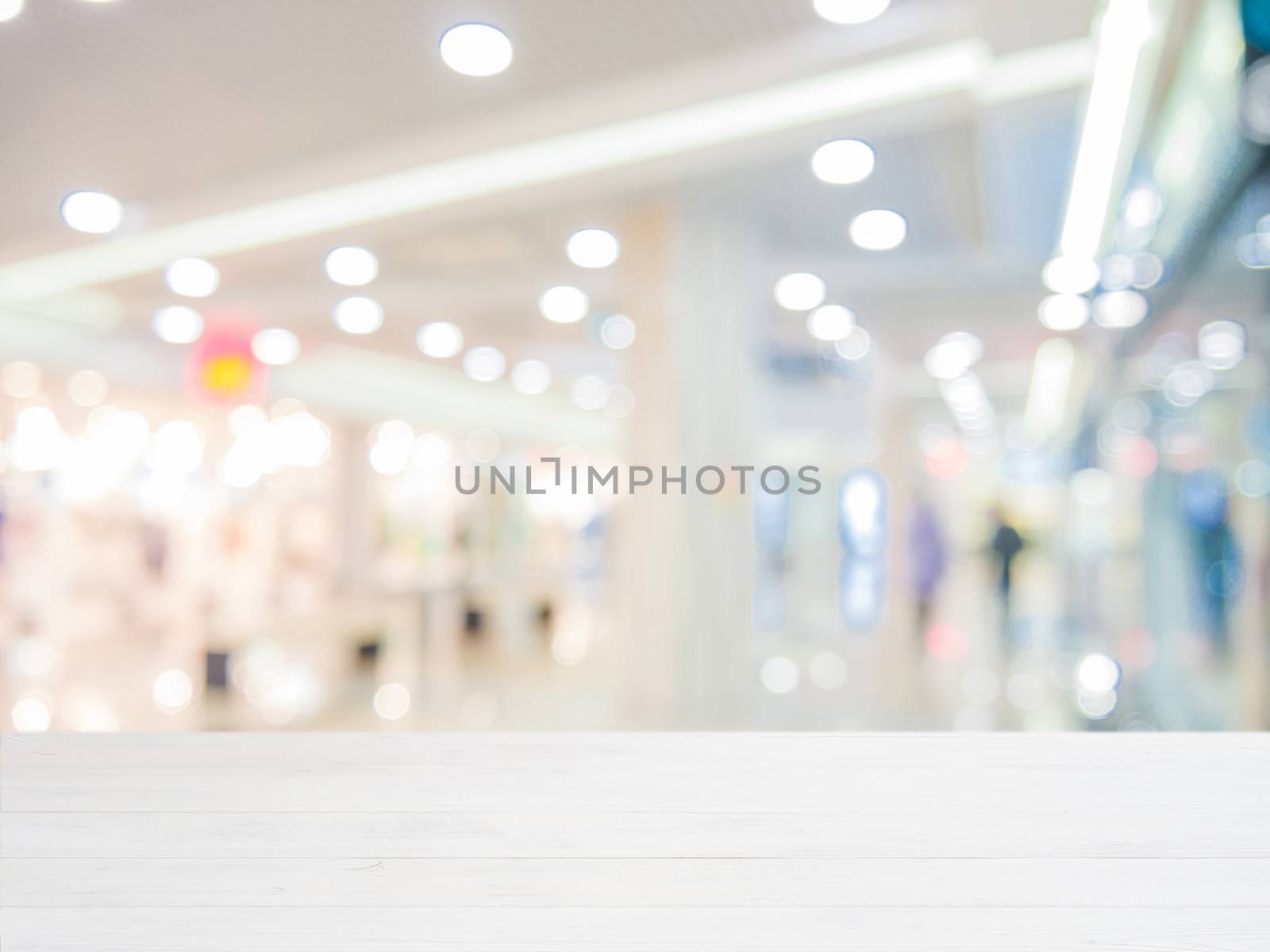 White wooden board empty table in front of blurred background. Perspective white wood over blur in shopping mall - can be used for display or montage your products. Mock up for display of product.