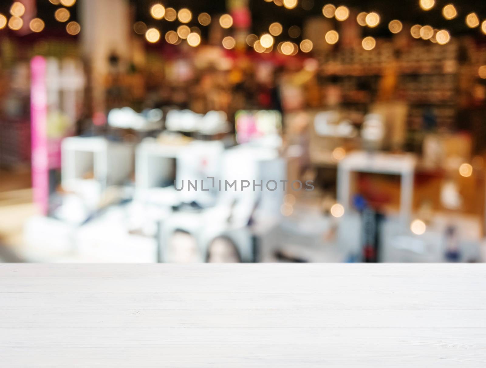 White wooden board empty table in front of blurred background. Perspective white wood over blur in shopping shoes store. Mockup for display or montage of product.