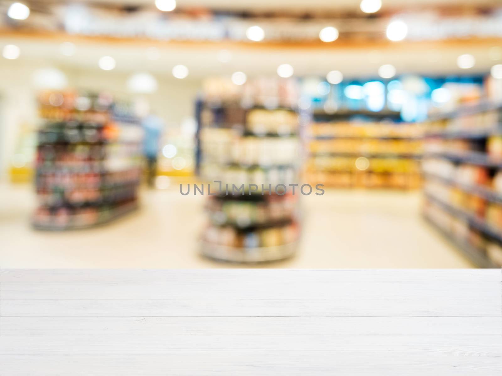 White wooden board empty table in front of blurred background. Perspective white wood over blur in supermarket - can be used for display or montage your products. Mockup for display of product.