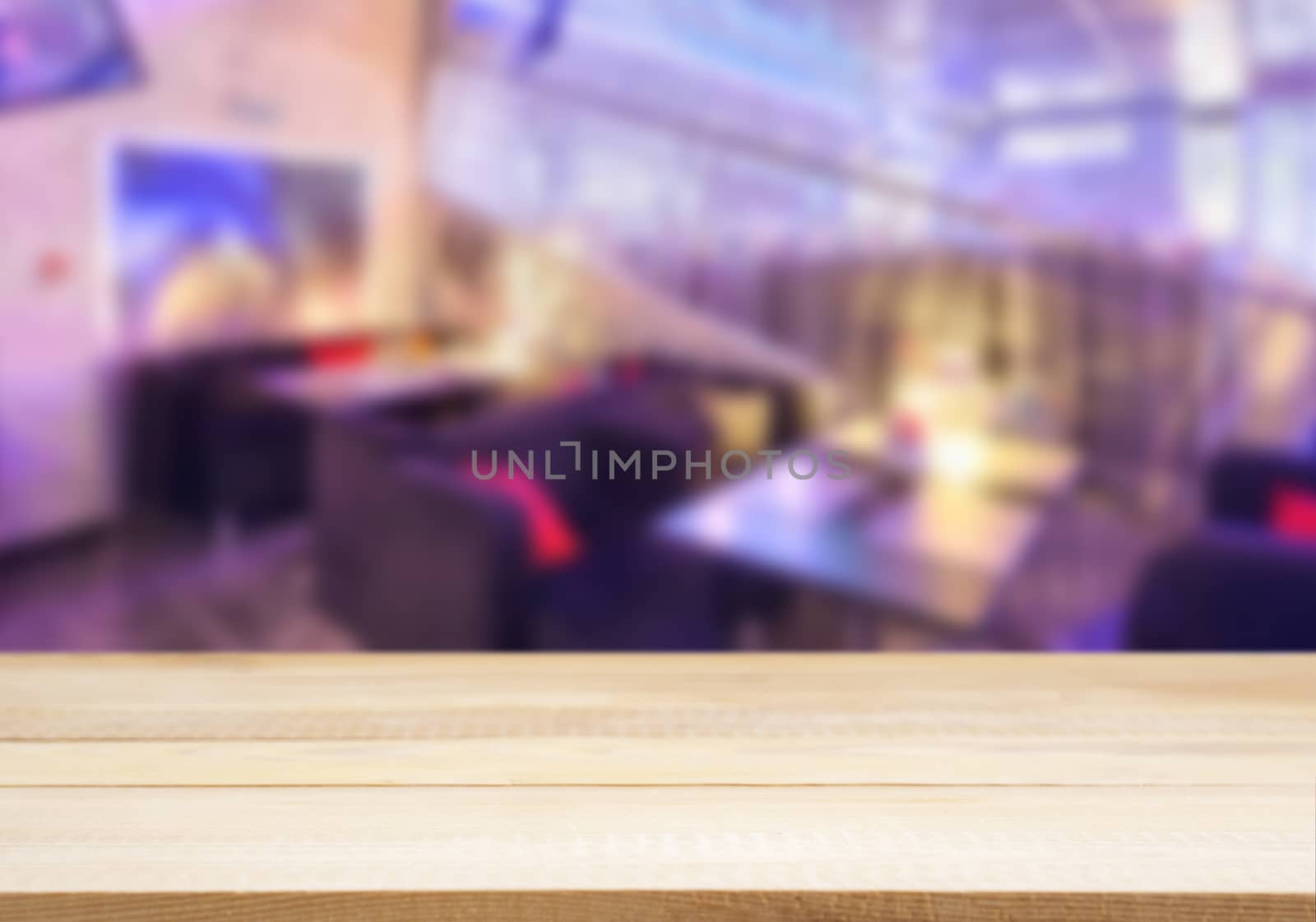 Wooden board empty table in front of blurred cafe by fascinadora